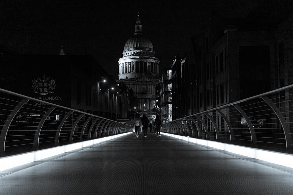 a person walking across a bridge at night