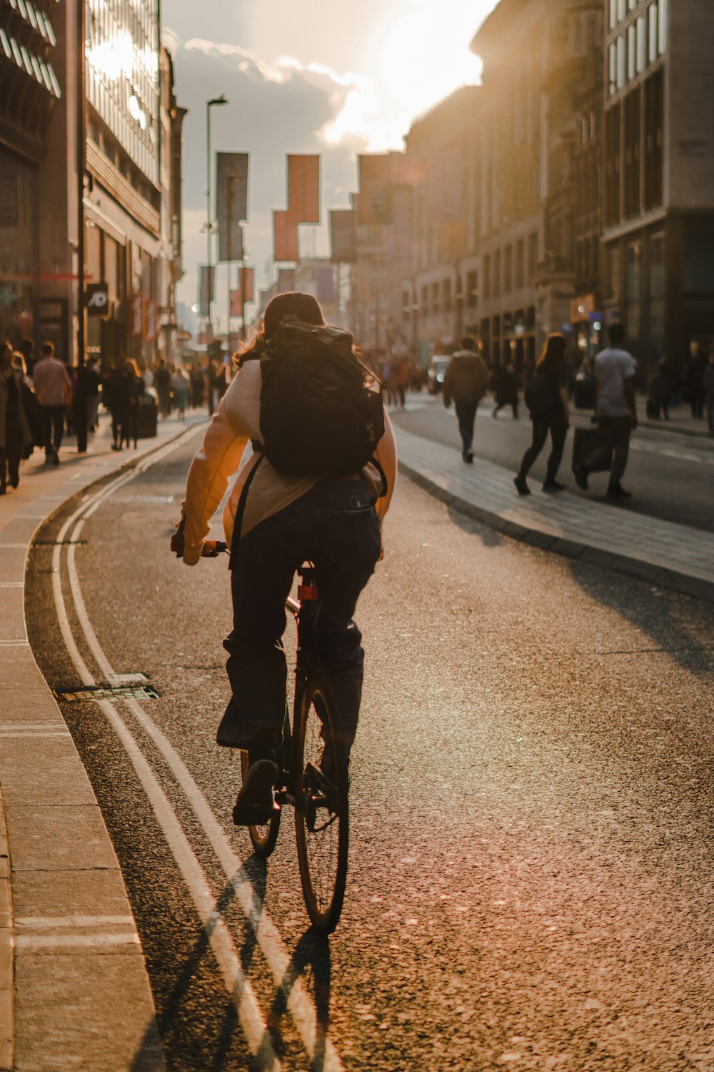 a man riding a bike down a street next to tall buildings