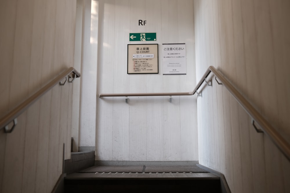 there is a sign on the wall above the stairs