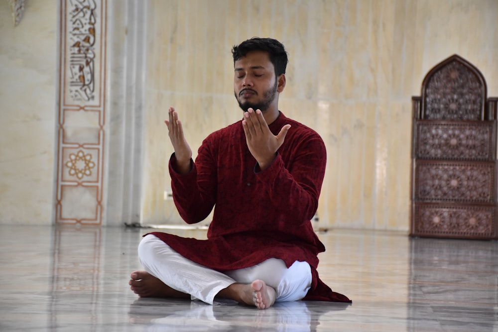 a man in a red outfit sitting on the floor