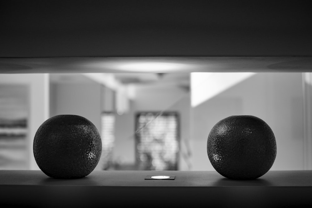 two oranges sitting on top of a table next to each other