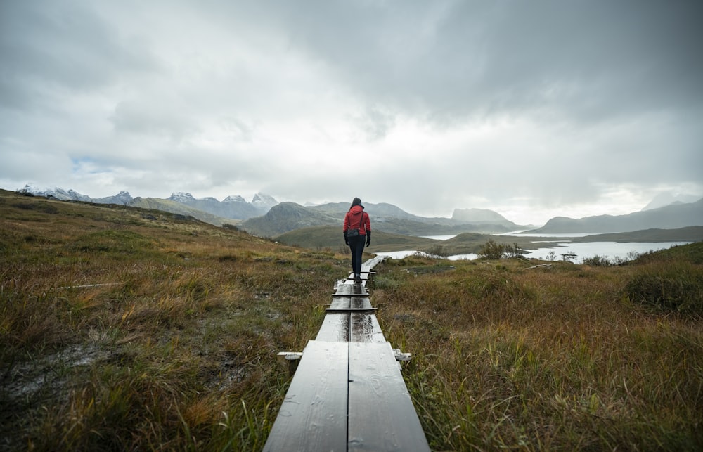 a person standing on a wooden walkway in a field