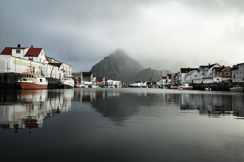 a body of water with houses and a mountain in the background