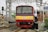 a red and yellow train pulling into a train station