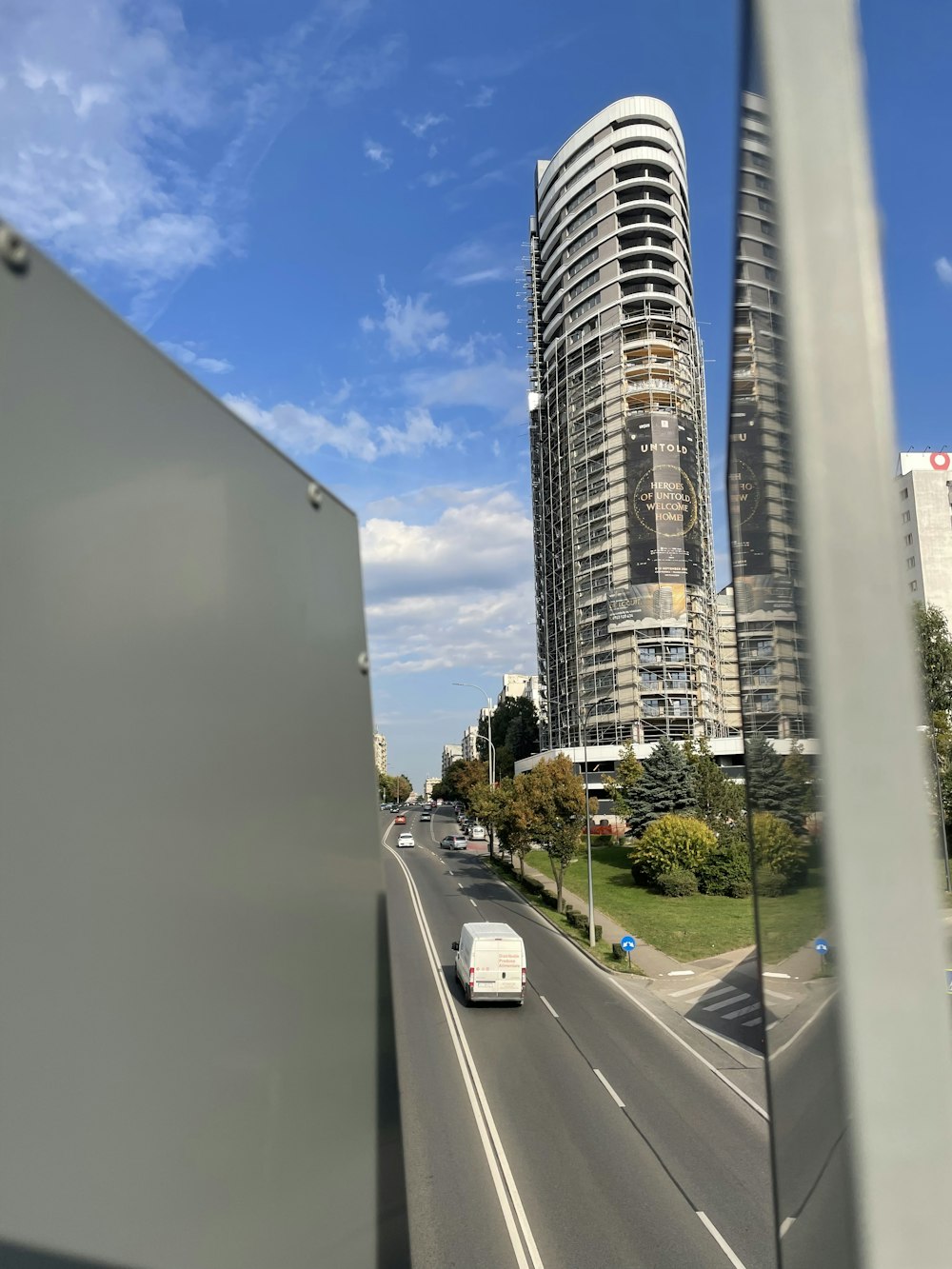 a white van driving down a street next to tall buildings