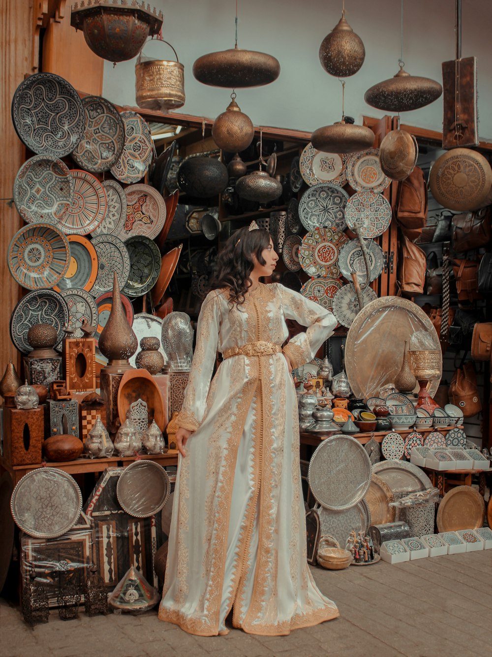 a woman standing in front of a display of pottery