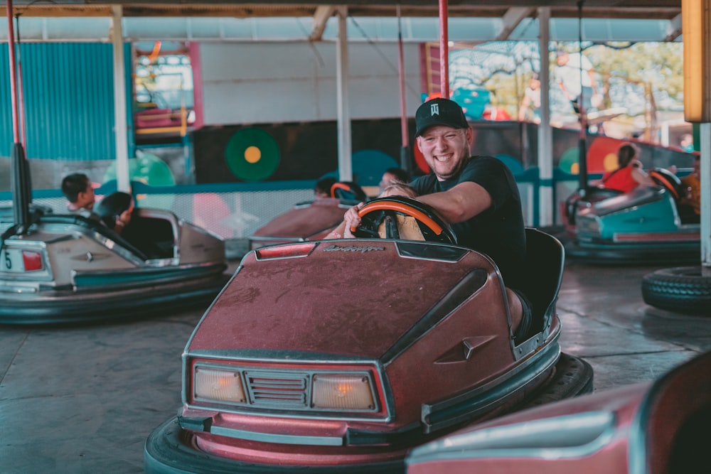 a man riding a bumper car at a carnival