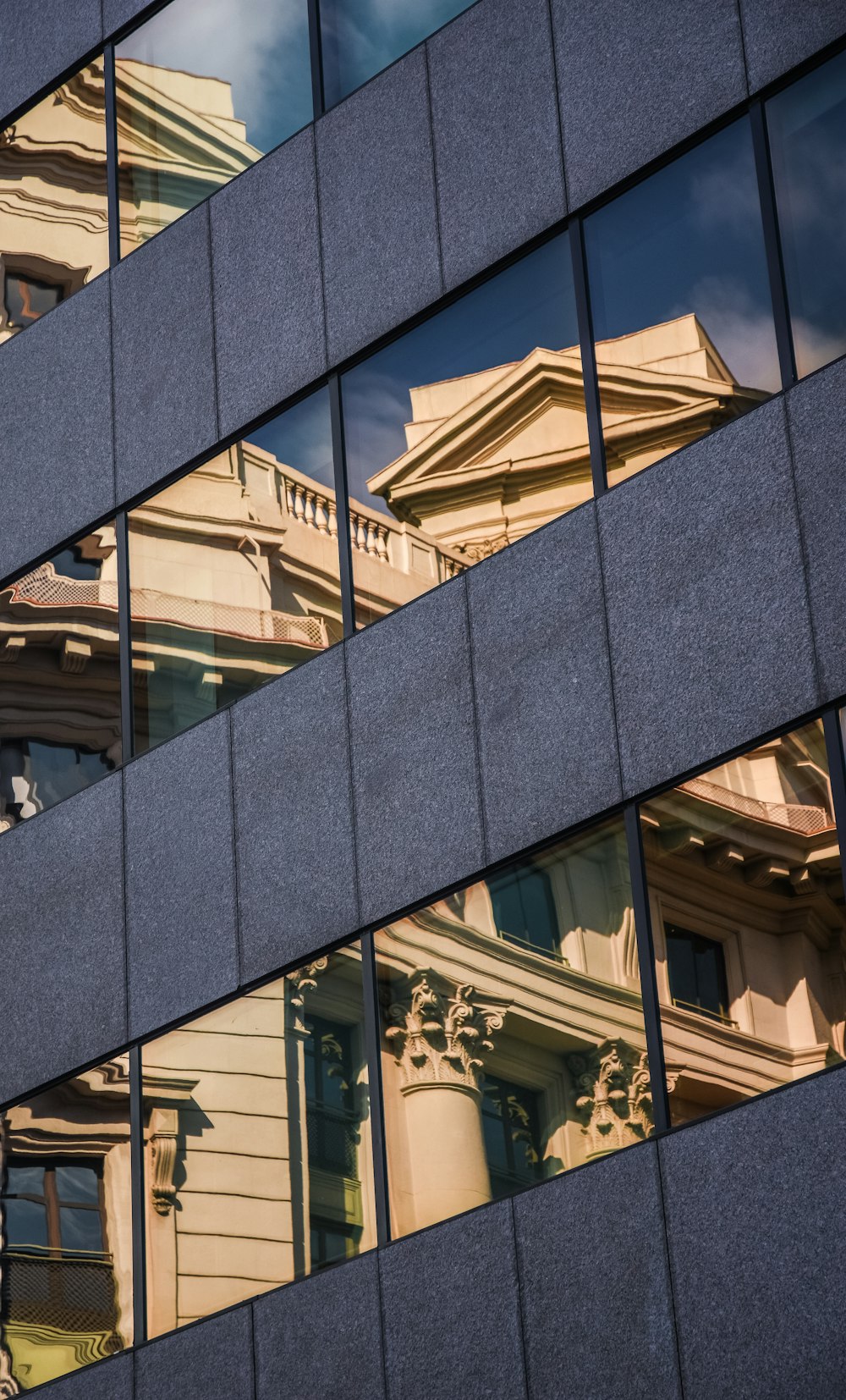 a reflection of a building in the windows of another building