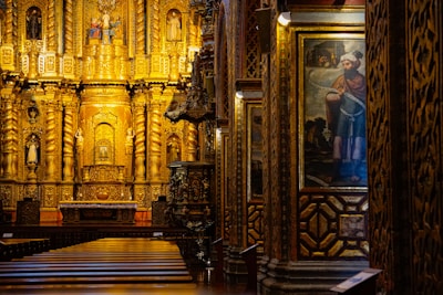 a church with a golden alter and paintings on the walls