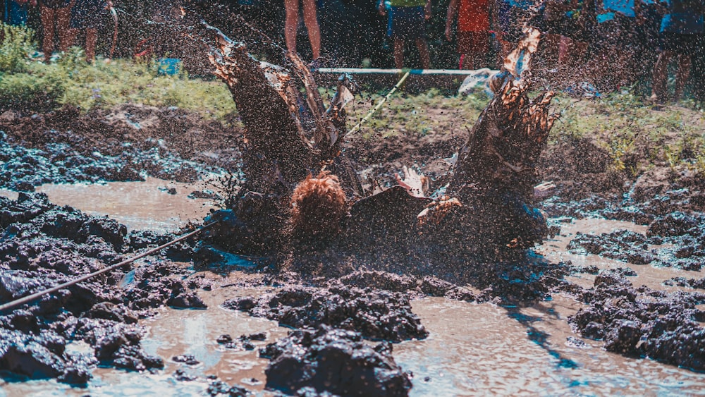 a group of people standing on top of a muddy field