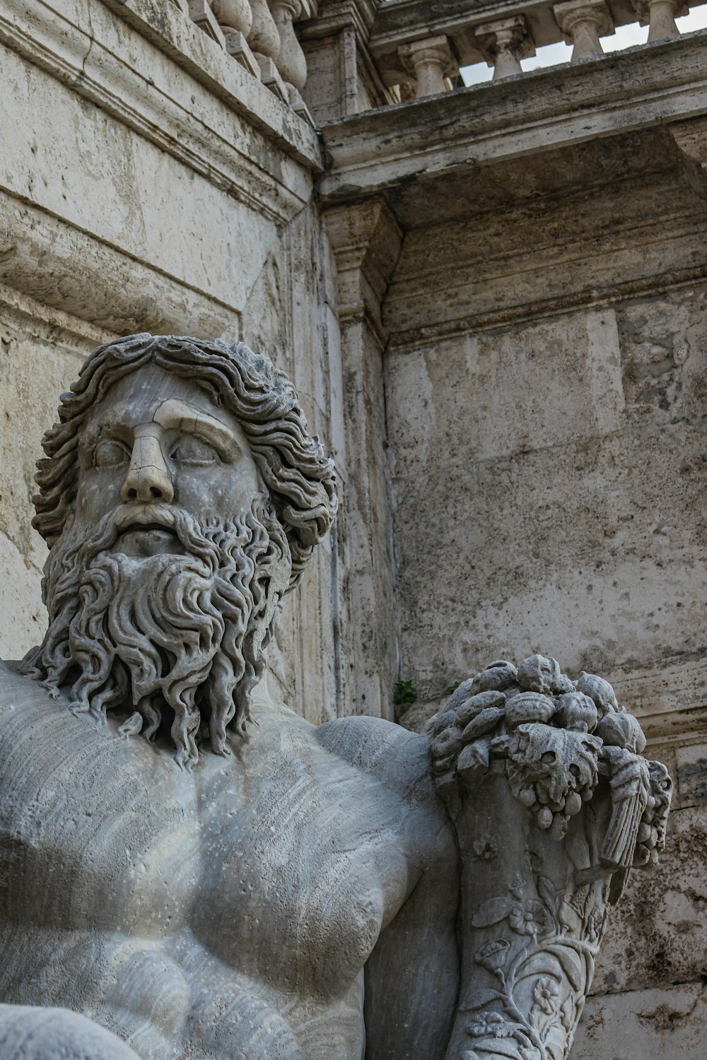 Eine Statue eines Mannes mit Bart, der eine Pflanze hält