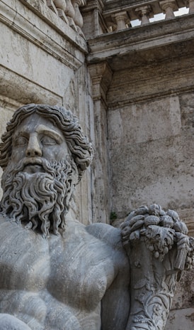 a statue of a man with a beard holding a plant