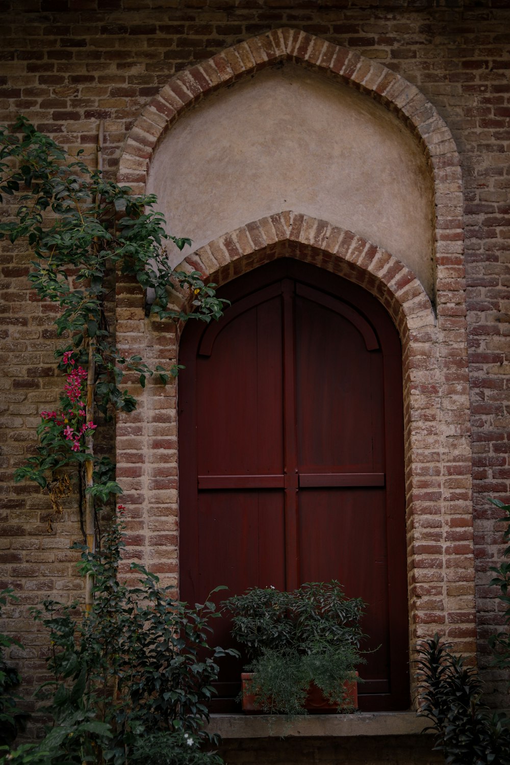 a brick building with a red door and window