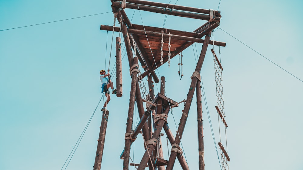 a man is climbing up a wooden structure