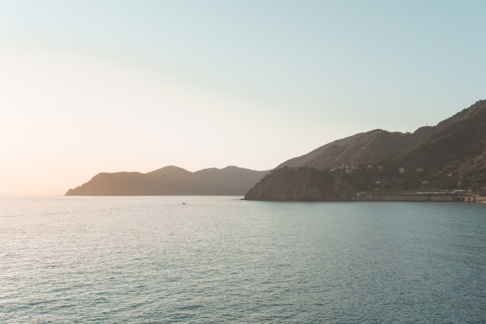 a body of water with mountains in the background