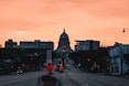 a city street at sunset with a dome in the background