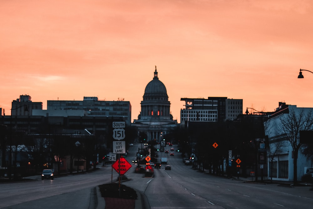 a city street at sunset with a dome in the background