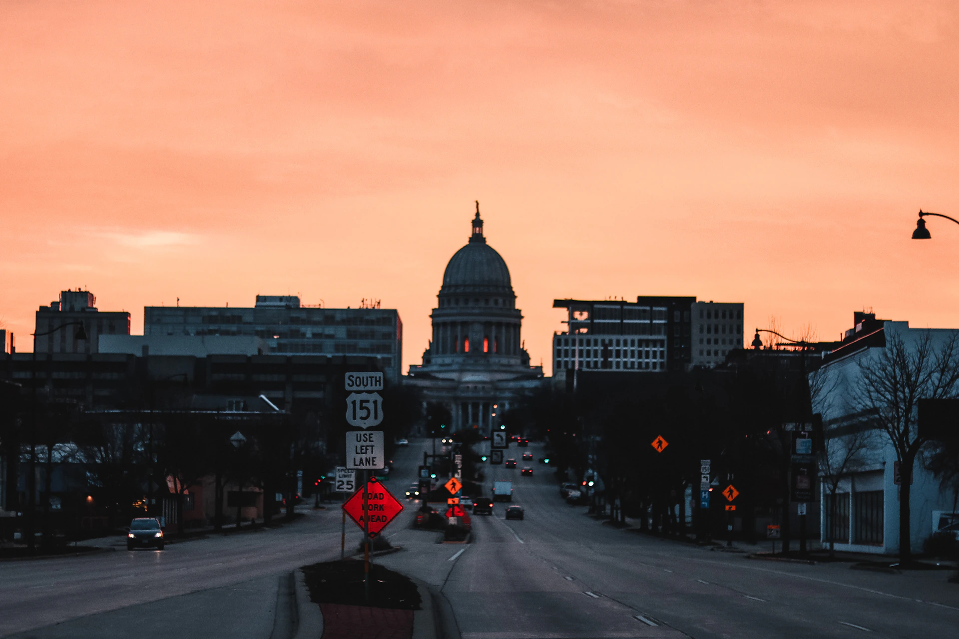 a city street at sunset with a dome in the background