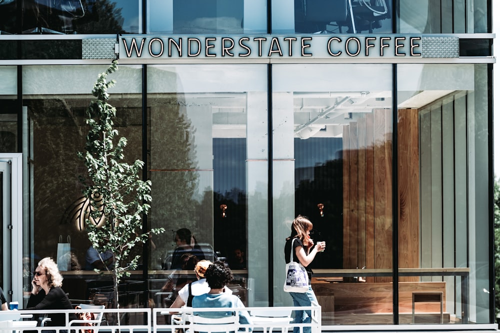 a group of people sitting outside of a coffee shop