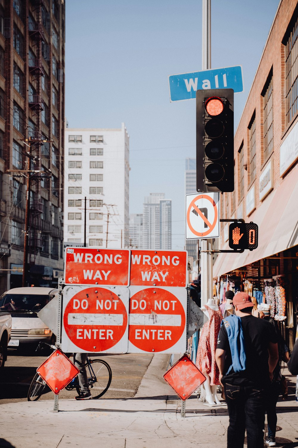 a group of people walking down a street next to a traffic light