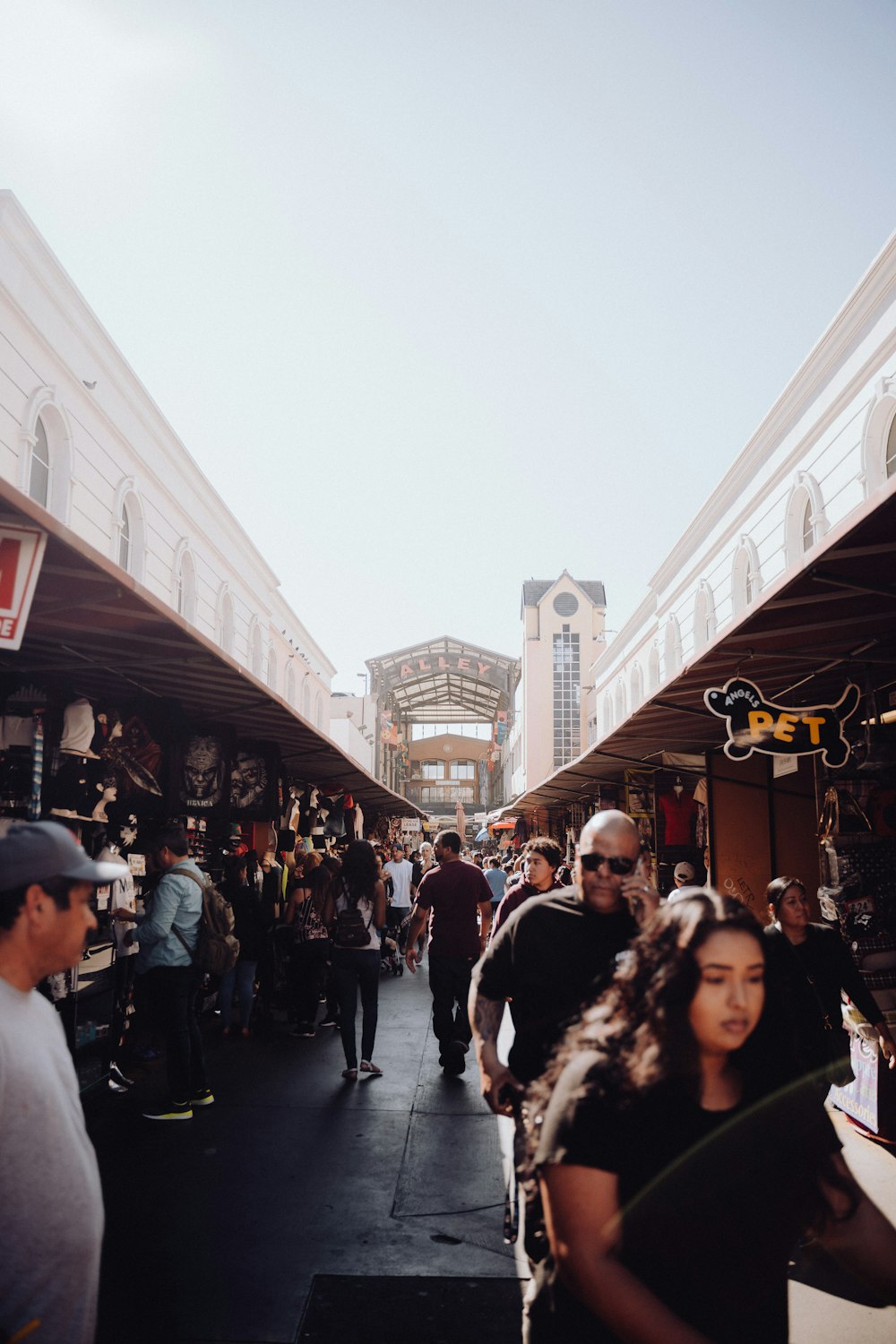 a group of people walking down a street next to tall buildings