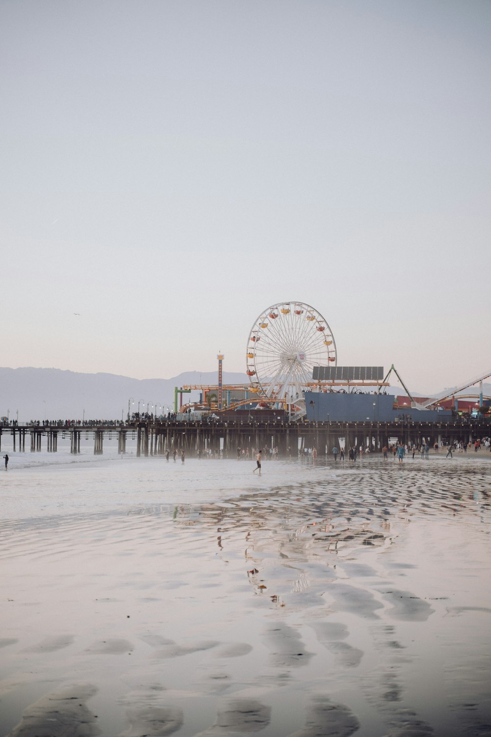 a ferris wheel sitting on top of a pier next to the ocean