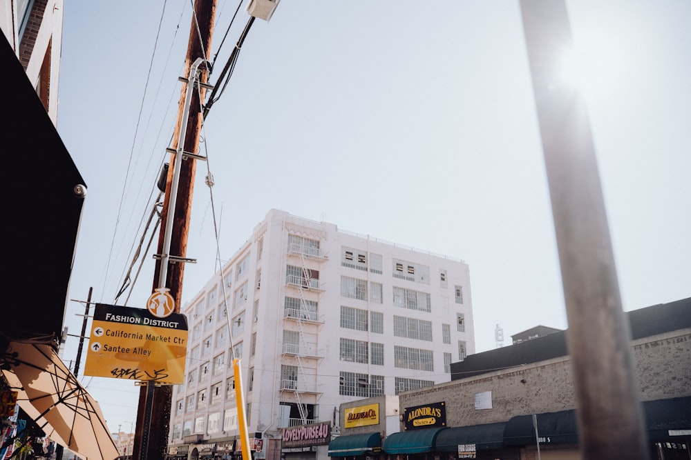 a yellow sign hanging from the side of a building