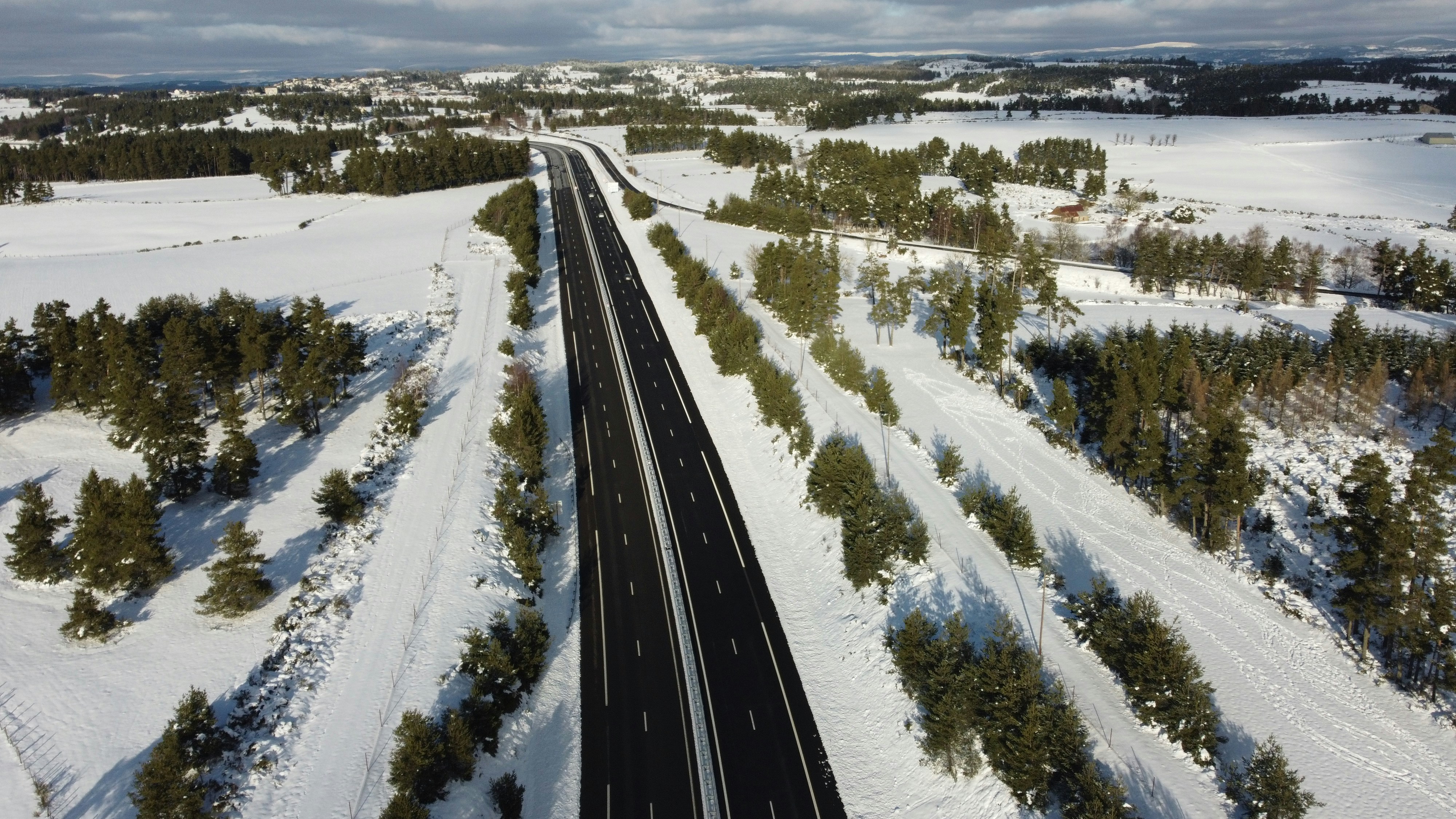 Luftaufnahme einer von Schnee umgebenen Straße