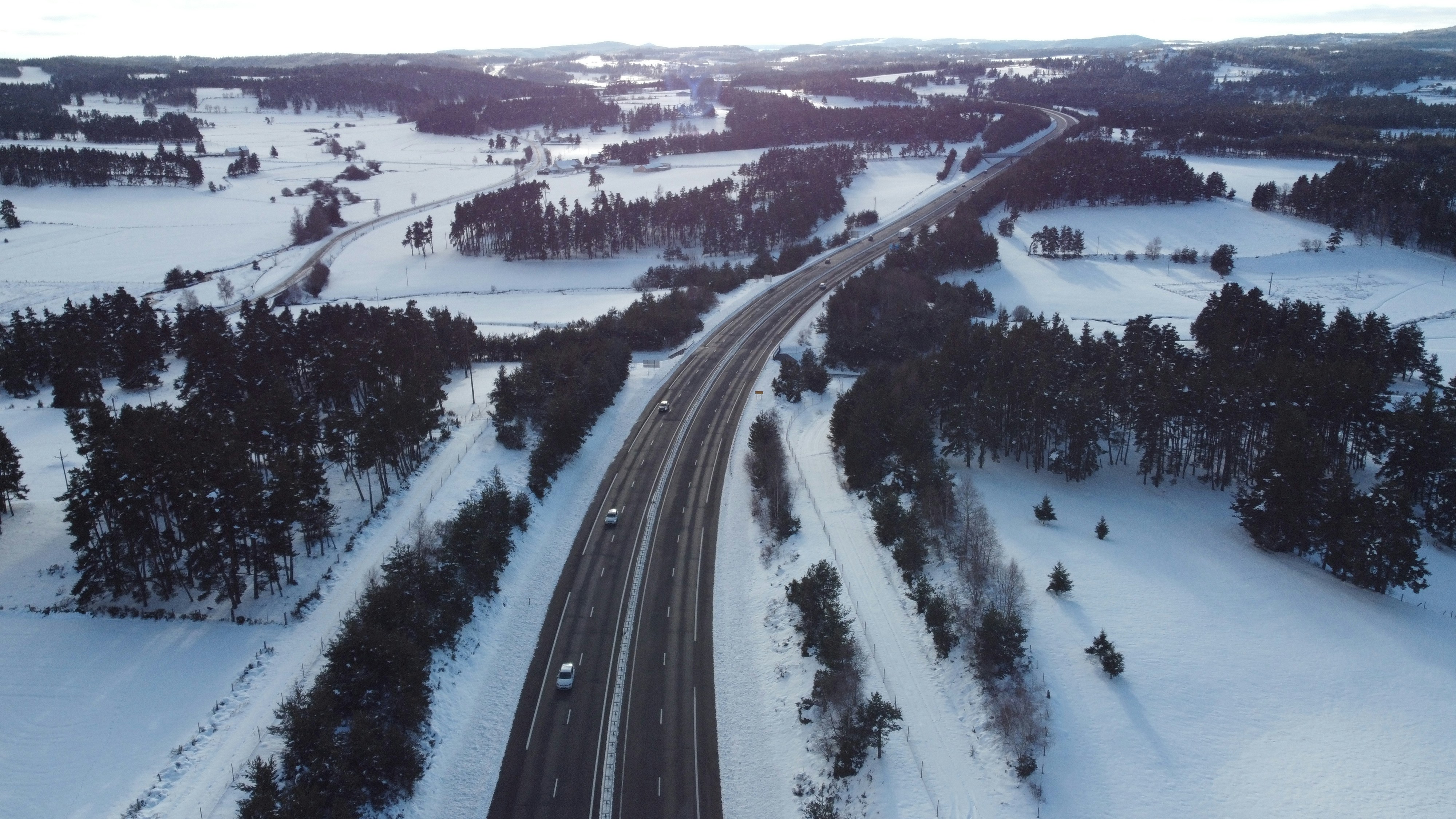 eine Luftaufnahme einer Straße, die von Schnee umgeben ist