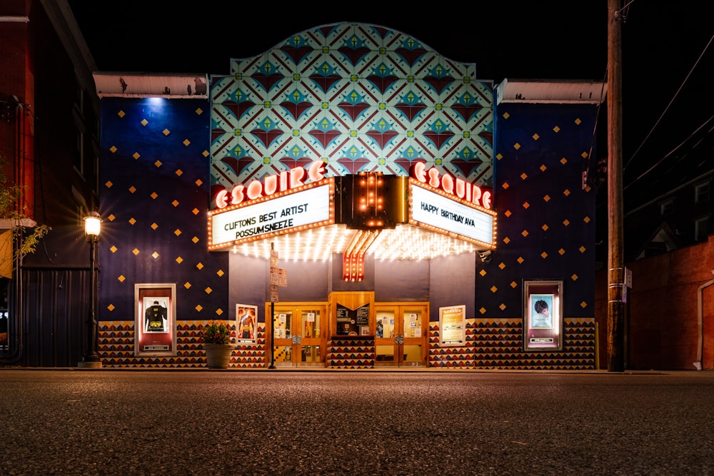 Un edificio de teatro con una carpa iluminada por la noche
