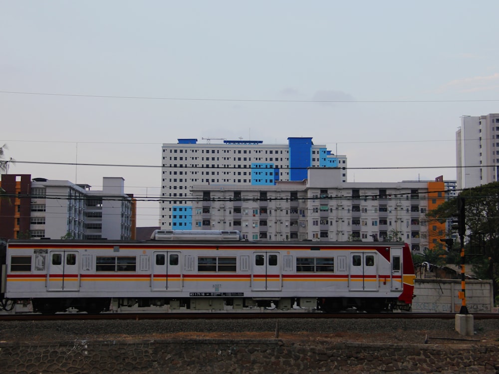 a train traveling through a city next to tall buildings