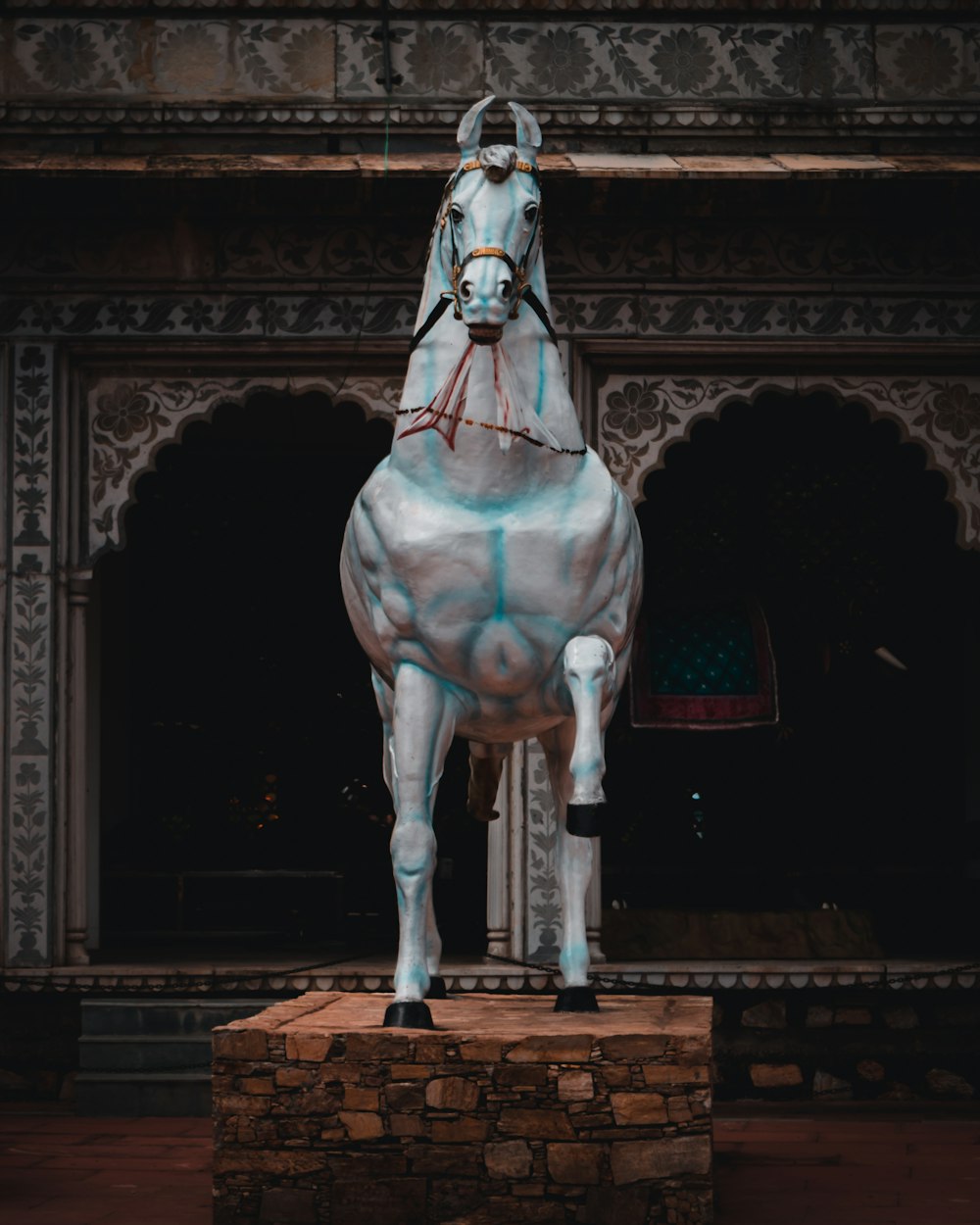 a statue of a white horse with blue paint on it's body