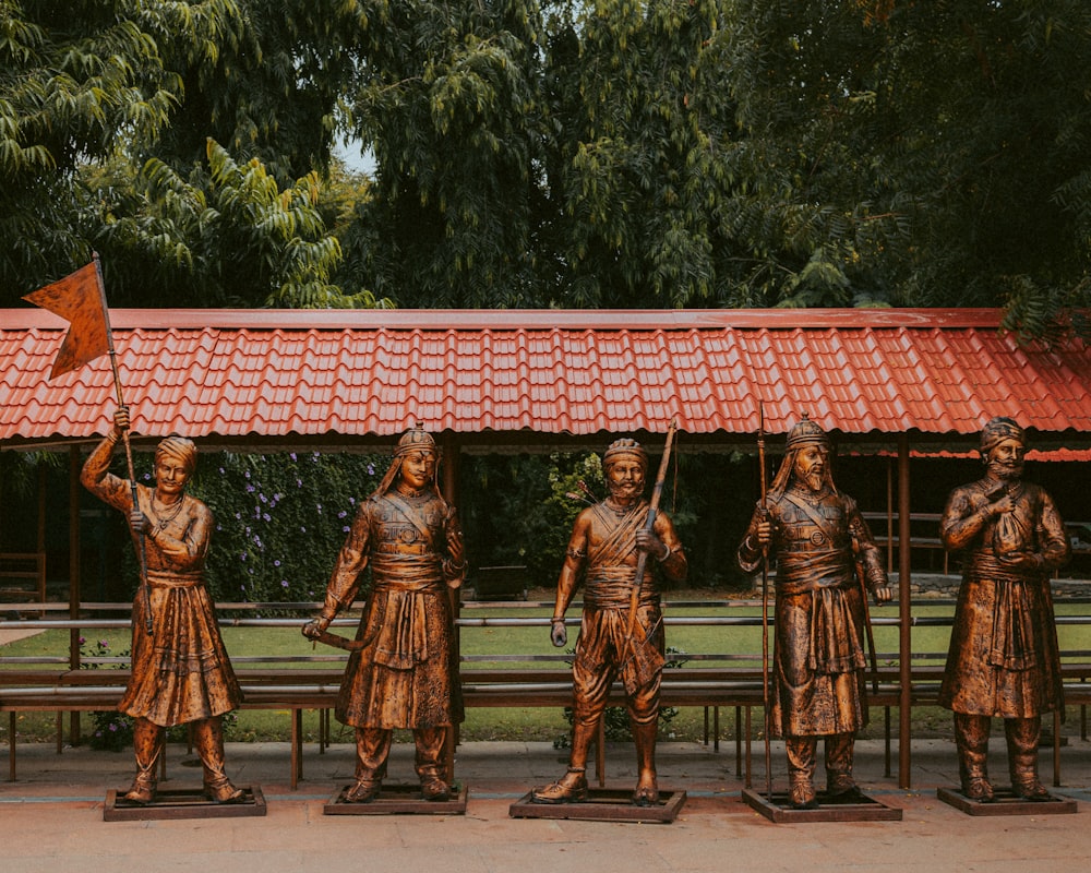 a group of statues of people holding a flag