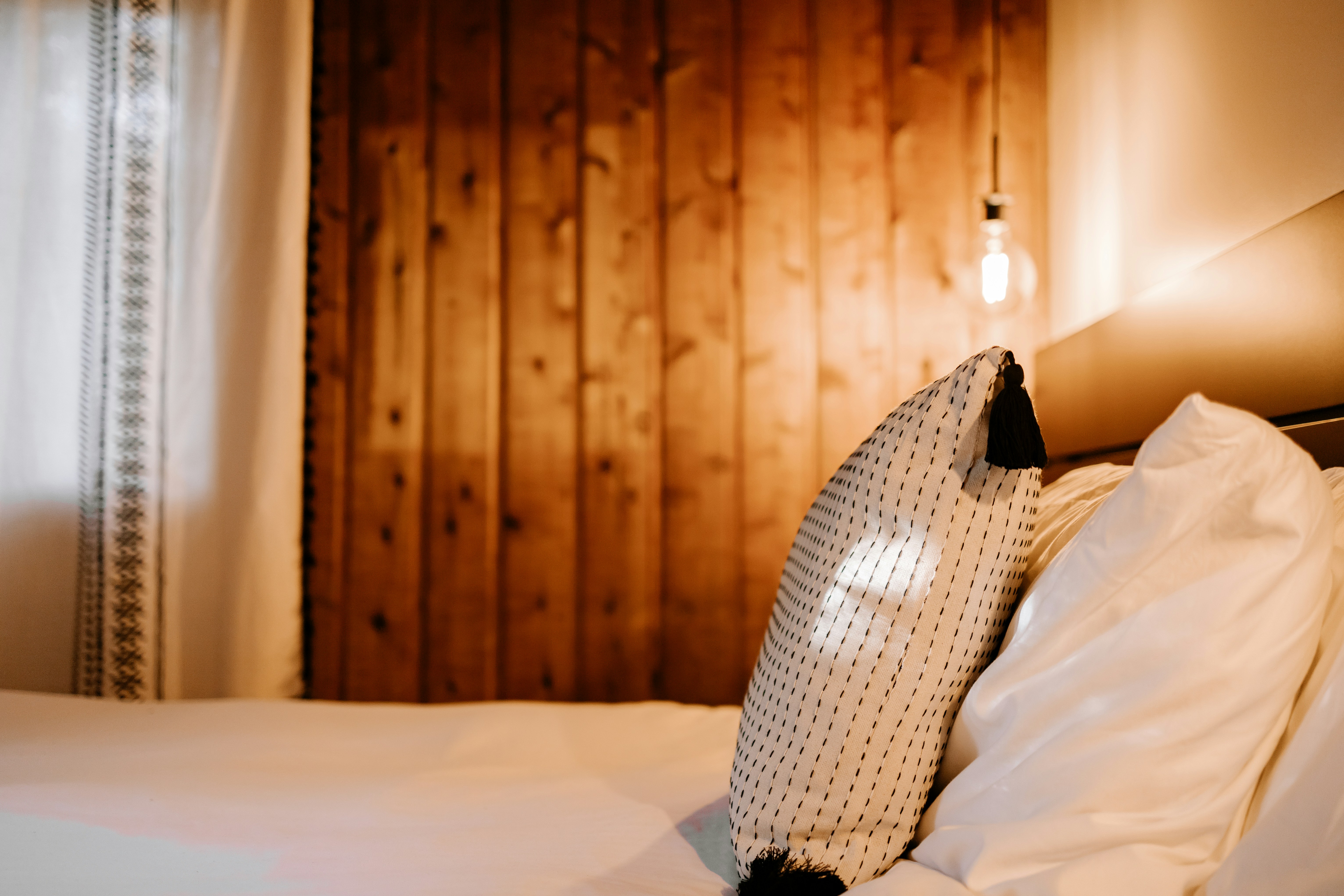 a bed with a white comforter and a wooden headboard