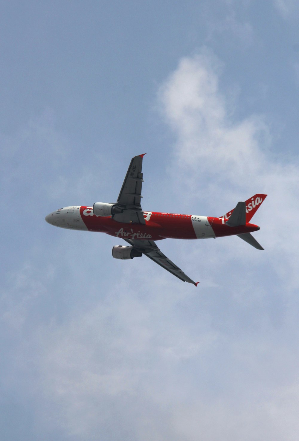 a red and white airplane flying in the sky