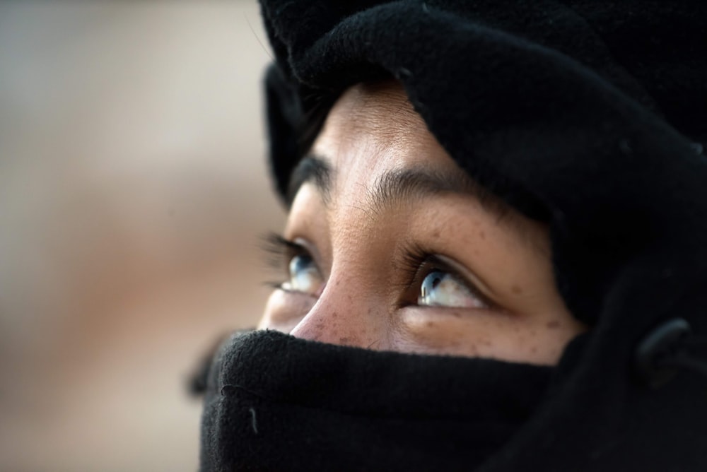 a close up of a woman wearing a black head scarf