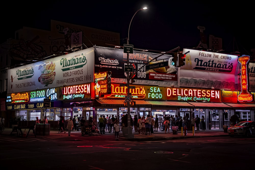 a group of people standing outside of a restaurant at night