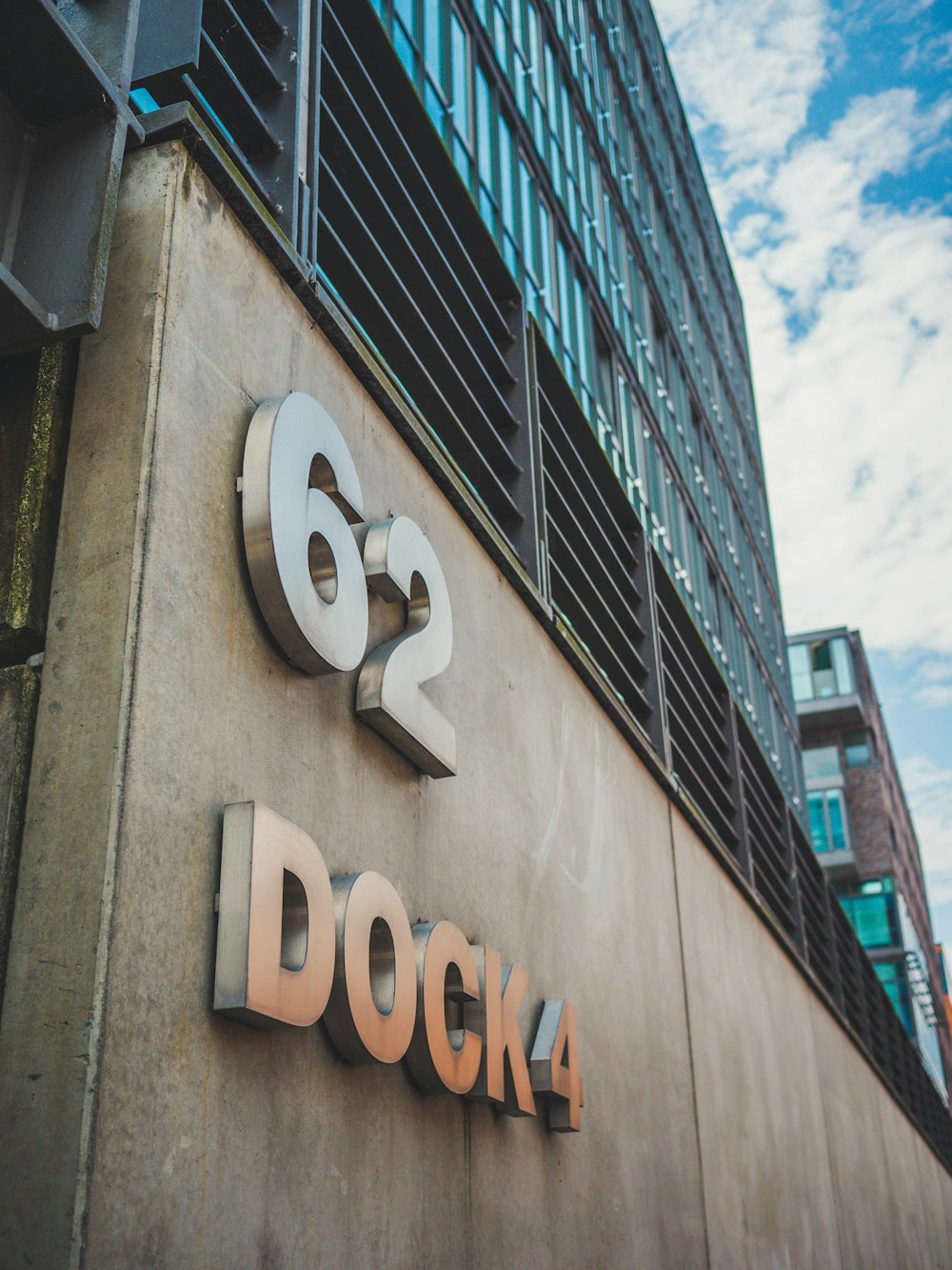 a sign on the side of a building with a sky background