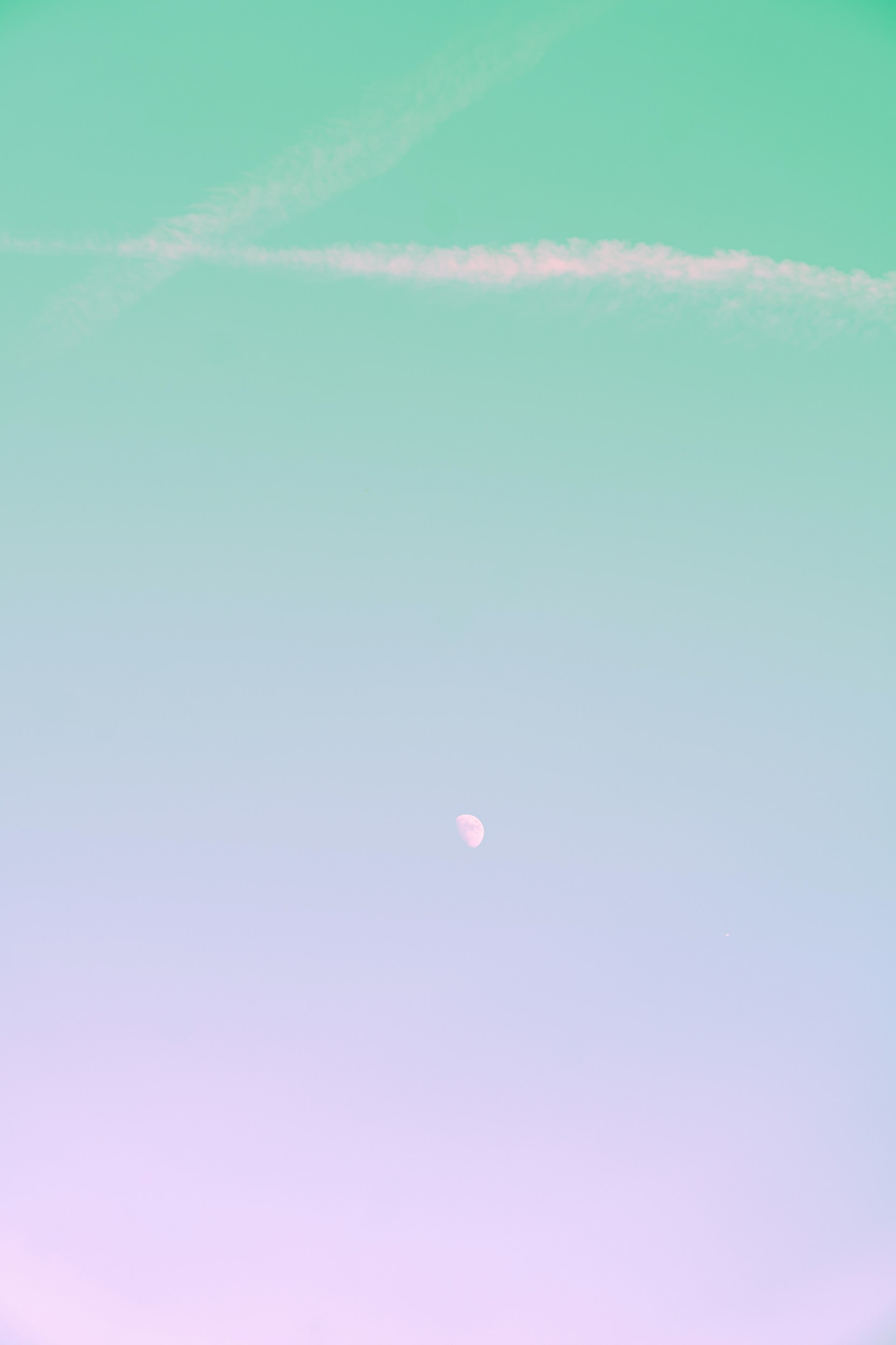 a plane flying in the sky with a contrail in the background