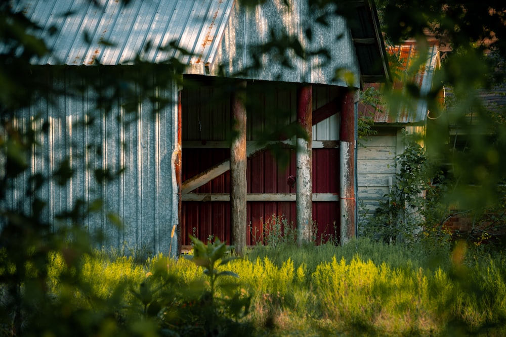 a barn with a metal roof and a red door