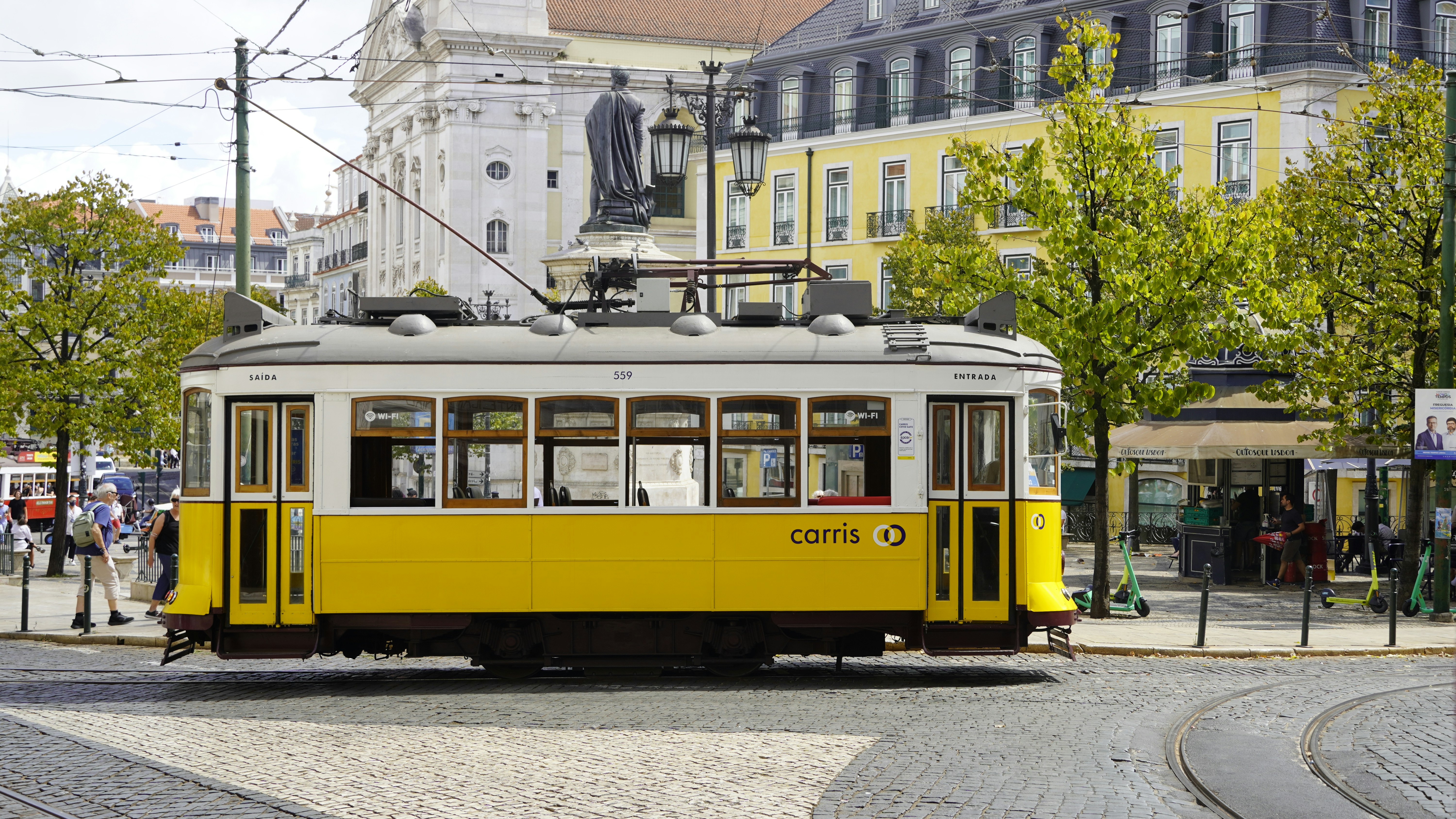 a yellow trolley car on a city street