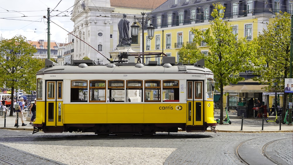 a yellow trolley car on a city street