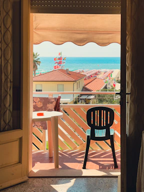 Cozy beachfront apartment balcony with sunset view and inviting seating.