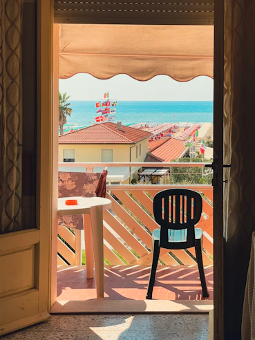 Chic apartment balcony with ocean horizon and comfortable seating.