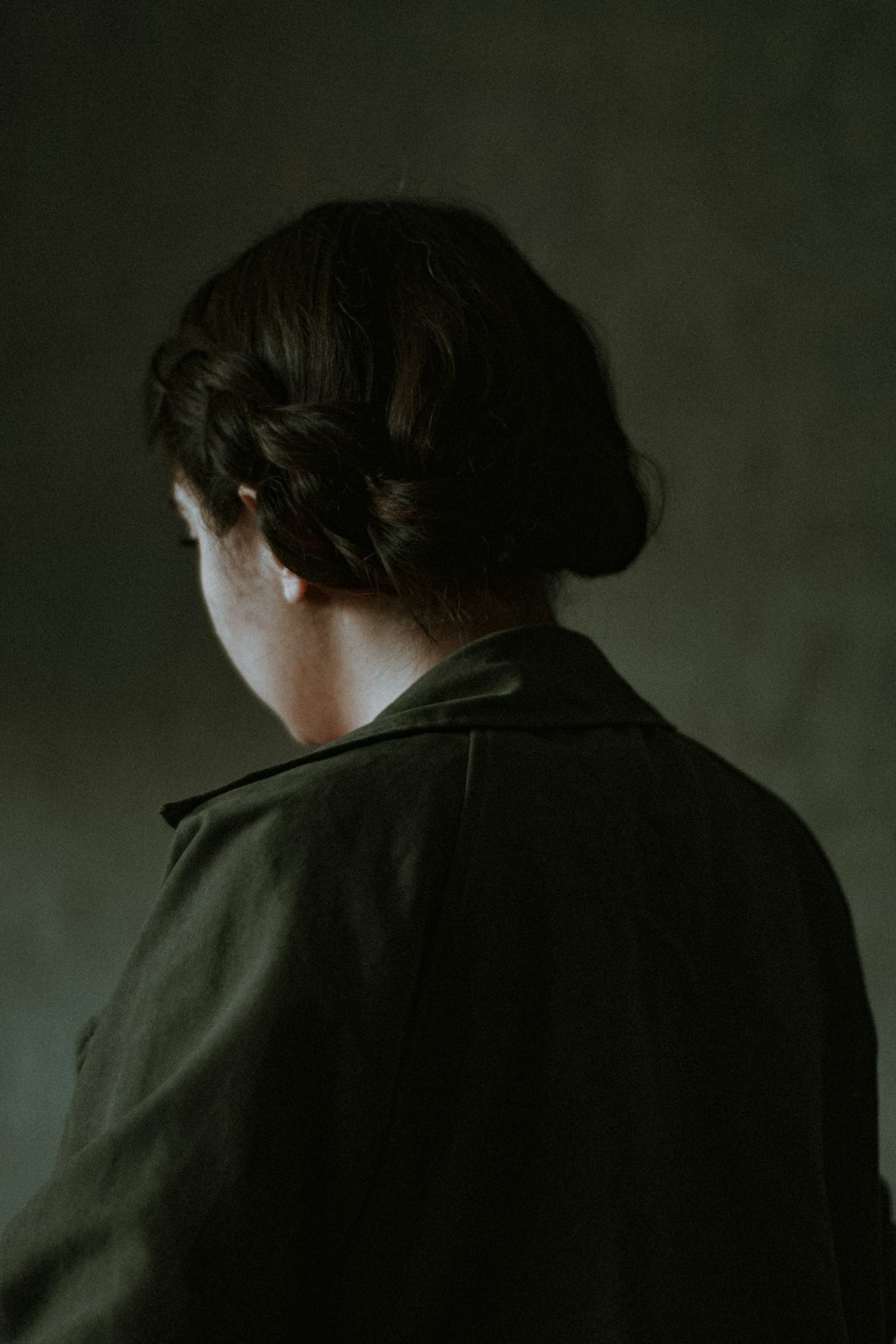 a woman in a dark room with her back to the camera