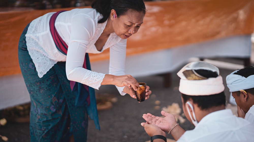 a woman is handing something to a man