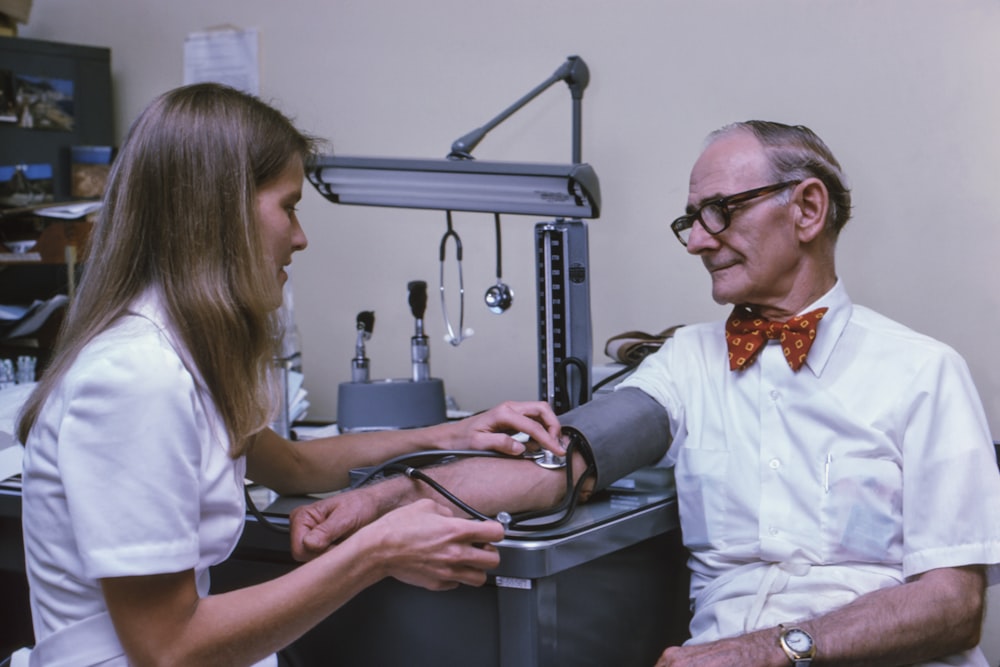 un médico que examina el tobillo de un paciente con un estetoscopio