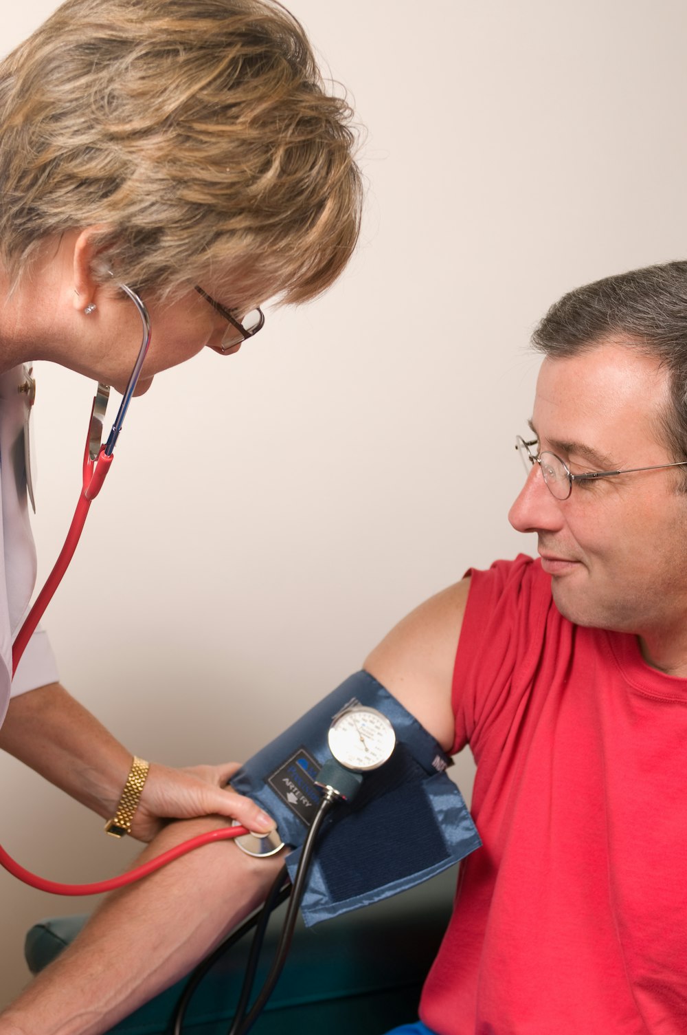 Ein Arzt, der den Blutdruck eines Patienten mit einem Stethoskop überprüft
