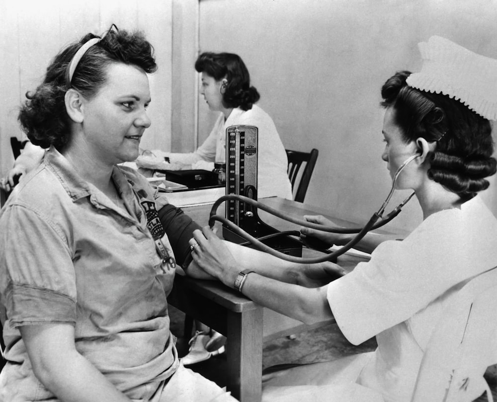 a nurse checking a patient's blood with a stethoscope