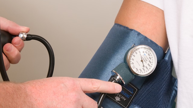 a doctor checking the blood pressure of a patient by CDC (@cdc)